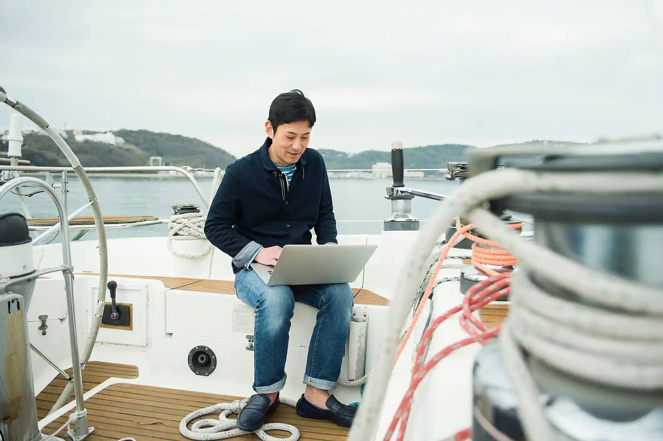 man using a laptop in his yacht